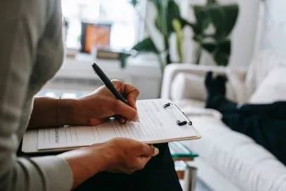 Blog image - person filling in a paper form on a clipboard