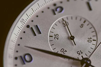 Closeup of an analog watch face showing the numbers 10 through 1