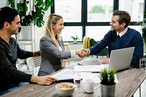 Financial adviser shaking hands with a couple