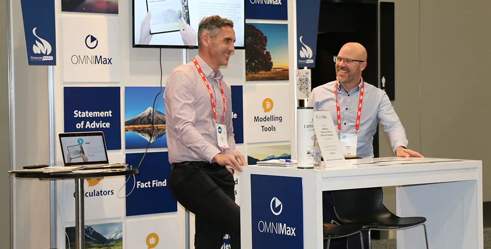 OMNIMax's Jonathan & Greg standing in an OMNIMax booth at a conference
