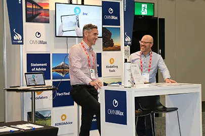 OMNIMax's Jonathan & Greg standing in an OMNIMax booth at a conference